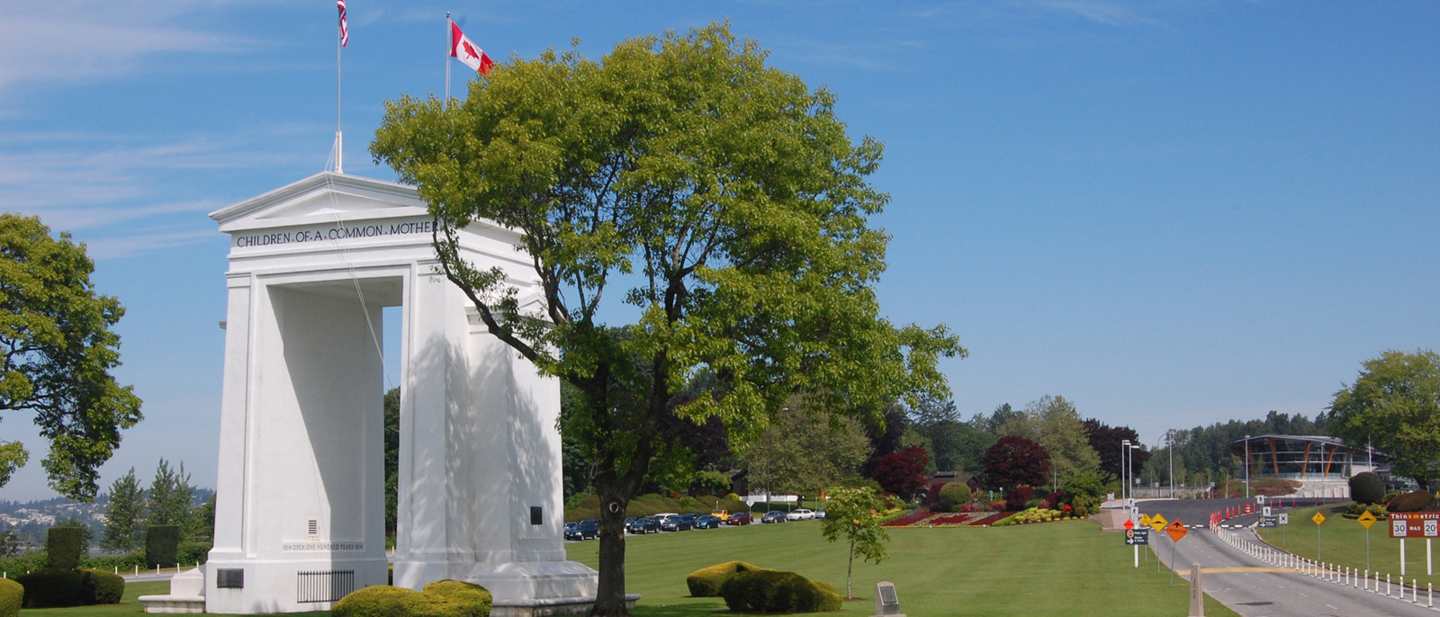 The Peace Arch on the border between Blaine, Washington and Surrey, British Columbia, inscribed “Children of a common mother”, with the United States and Canadian flags above it